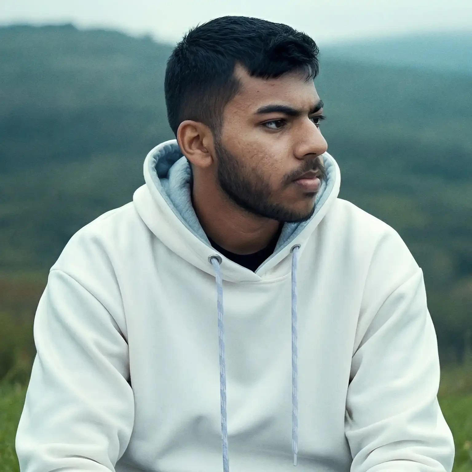 Sakib outdoors in a white hoodie